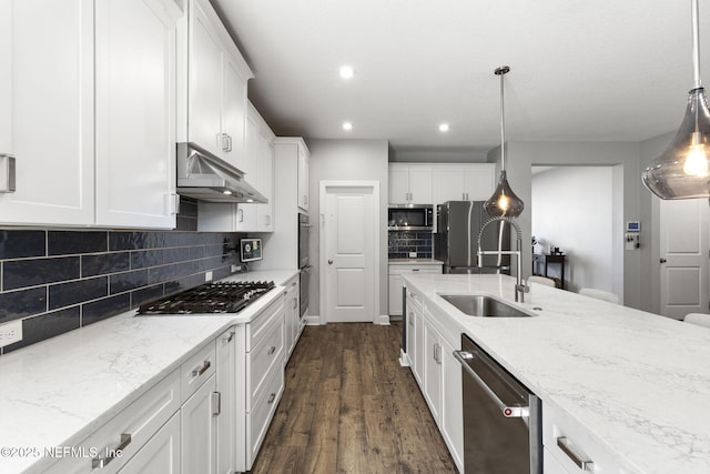 kitchen featuring under cabinet range hood, a sink, dark wood finished floors, appliances with stainless steel finishes, and white cabinets