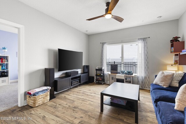 living room featuring a ceiling fan and light wood finished floors