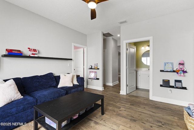 living room with visible vents, baseboards, and wood finished floors