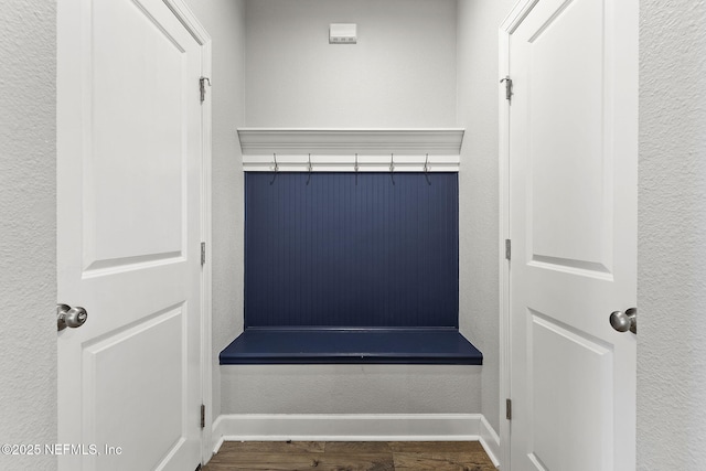 mudroom featuring wood finished floors, baseboards, and a textured wall