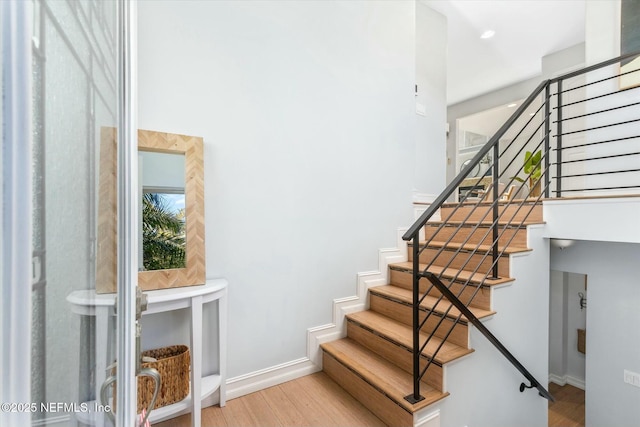 stairway featuring baseboards and wood finished floors