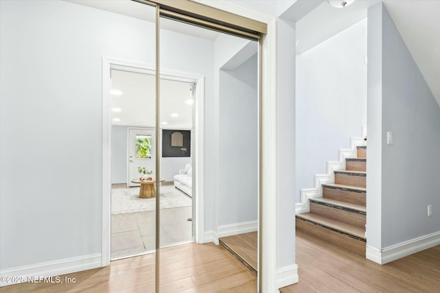 stairs with recessed lighting, baseboards, and wood finished floors