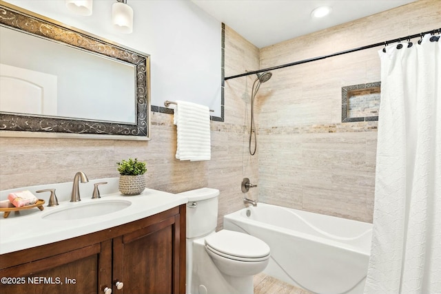 bathroom featuring toilet, vanity, tile walls, and shower / tub combo