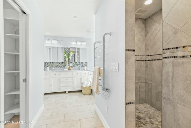 full bath with baseboards, double vanity, a sink, decorative backsplash, and a walk in shower