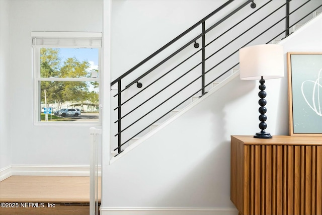 stairway with baseboards and wood finished floors