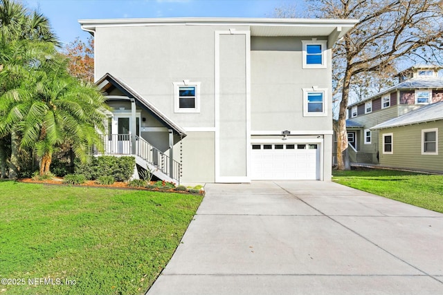 view of front of property with a front lawn, an attached garage, driveway, and stucco siding