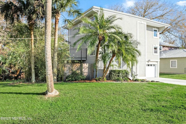 view of front of property featuring a front lawn, an attached garage, driveway, and stucco siding