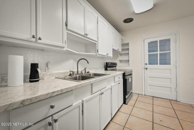 kitchen with backsplash, light tile patterned floors, electric range, white cabinetry, and a sink