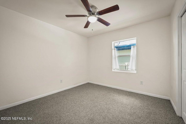 carpeted empty room featuring a ceiling fan and baseboards