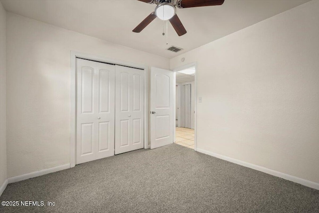 unfurnished bedroom with visible vents, a closet, carpet flooring, baseboards, and ceiling fan