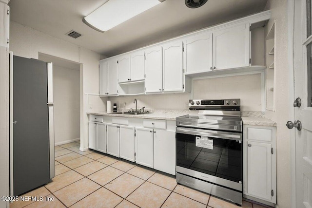 kitchen featuring visible vents, light tile patterned floors, appliances with stainless steel finishes, white cabinetry, and a sink