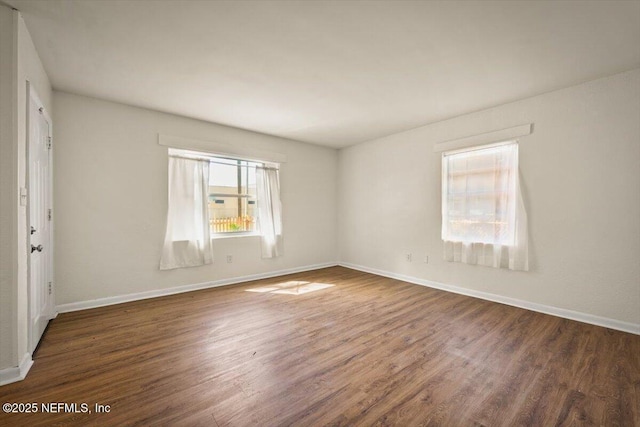 spare room with wood finished floors and baseboards