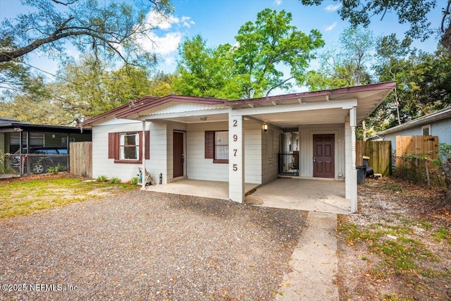 view of front of home featuring a carport, fence, and driveway