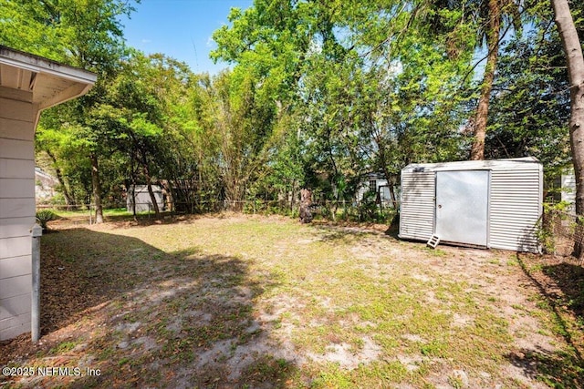 view of yard with a storage unit, an outdoor structure, and fence