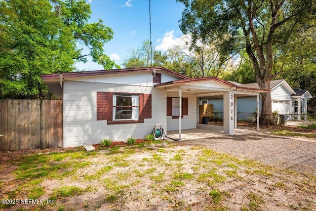 view of front of house featuring a carport and fence