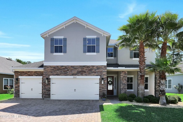 view of front facade featuring stone siding, stucco siding, decorative driveway, and roof with shingles