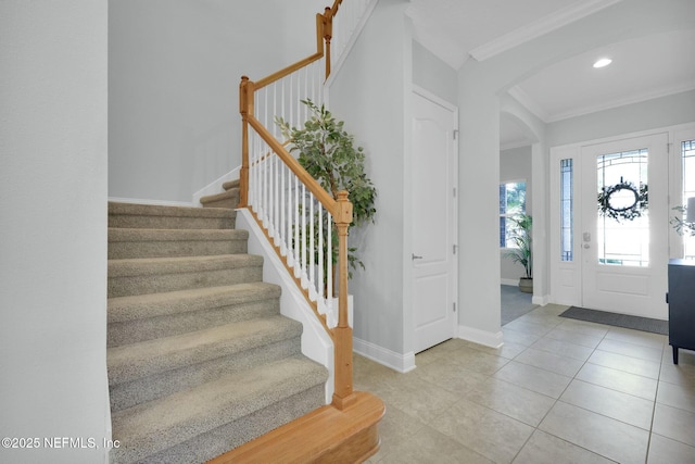 entrance foyer with crown molding, baseboards, stairs, recessed lighting, and light tile patterned flooring