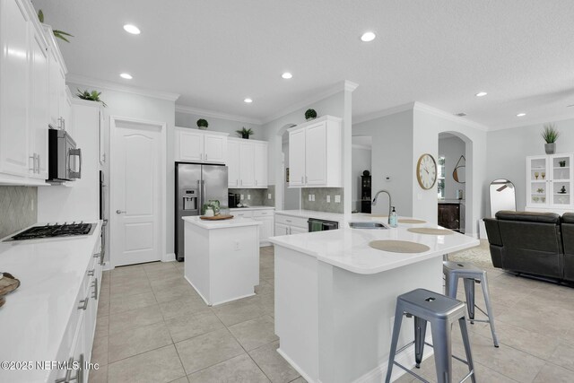 163 Medio Dr, Saint Augustine, FL 32095 - kitchen featuring a sink, gas cooktop, a kitchen breakfast bar, stainless steel fridge, and arched walkways