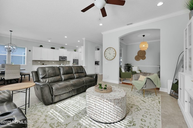 163 Medio Dr, Saint Augustine, FL 32095 - living room with baseboards, recessed lighting, arched walkways, crown molding, and ceiling fan with notable chandelier