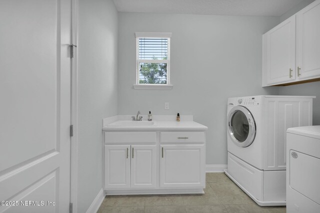 163 Medio Dr, Saint Augustine, FL 32095 - washroom featuring baseboards, light tile patterned flooring, cabinet space, a sink, and washing machine and dryer