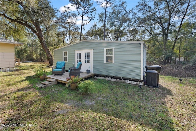 back of house featuring a deck, a lawn, and french doors