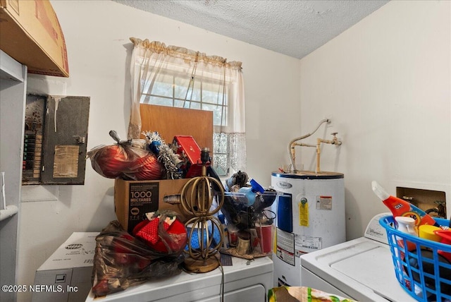 laundry room with a textured ceiling, electric water heater, laundry area, and washer and clothes dryer