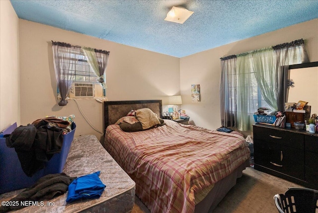 bedroom featuring cooling unit, a textured ceiling, and carpet floors