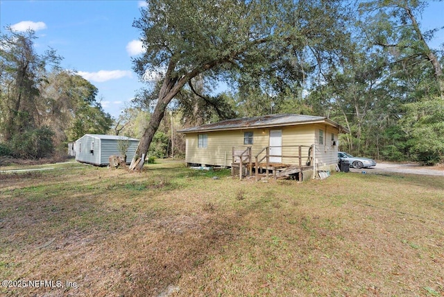 exterior space with a storage unit, a yard, and an outbuilding