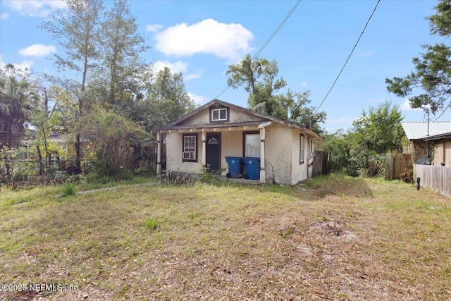 view of front of property featuring fence and stucco siding