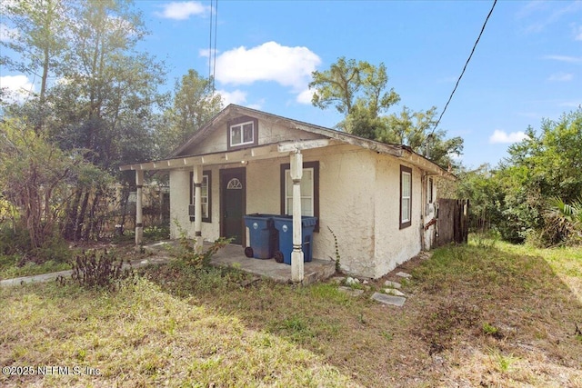 bungalow-style house featuring stucco siding