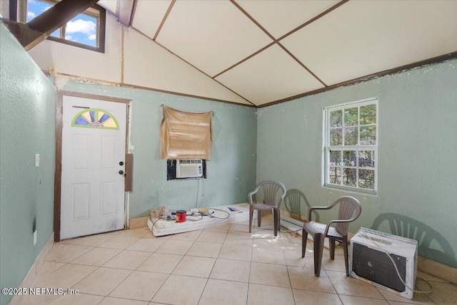 foyer with light tile patterned floors, cooling unit, plenty of natural light, and vaulted ceiling