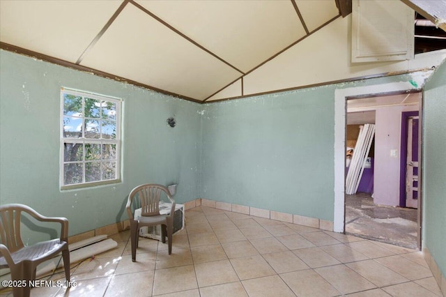 living area with lofted ceiling and light tile patterned flooring