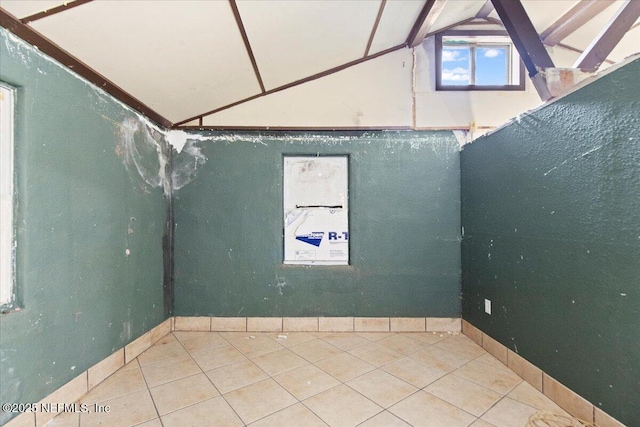 spare room with tile patterned floors and lofted ceiling