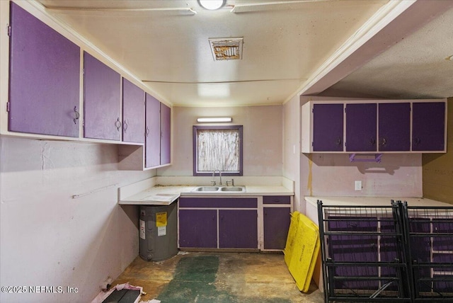 kitchen with water heater, concrete floors, light countertops, and a sink