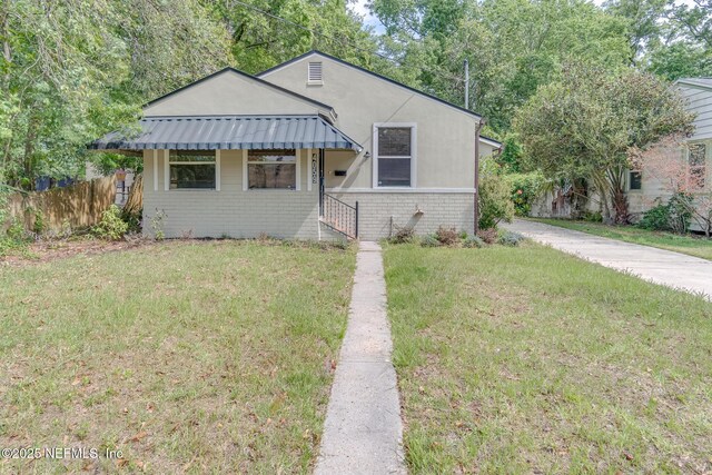 4059 College St, Jacksonville, FL 32205 - bungalow with brick siding, fence, a front yard, and stucco siding