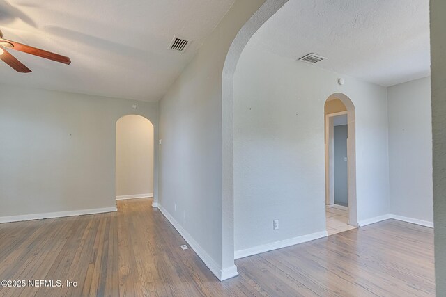 4059 College St, Jacksonville, FL 32205 - unfurnished room featuring visible vents, arched walkways, ceiling fan, and wood finished floors