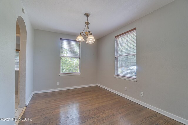 4059 College St, Jacksonville, FL 32205 - unfurnished room featuring plenty of natural light, arched walkways, and wood finished floors