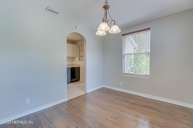 4059 College St, Jacksonville, FL 32205 - unfurnished room with visible vents, arched walkways, light wood-type flooring, baseboards, and a notable chandelier