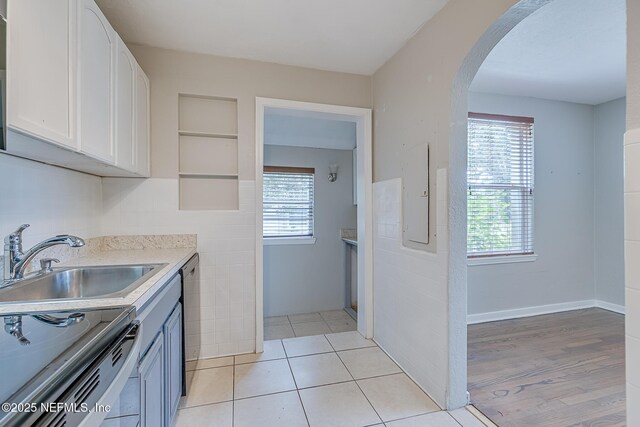 4059 College St, Jacksonville, FL 32205 - kitchen with electric range oven, arched walkways, white cabinets, a sink, and dishwasher