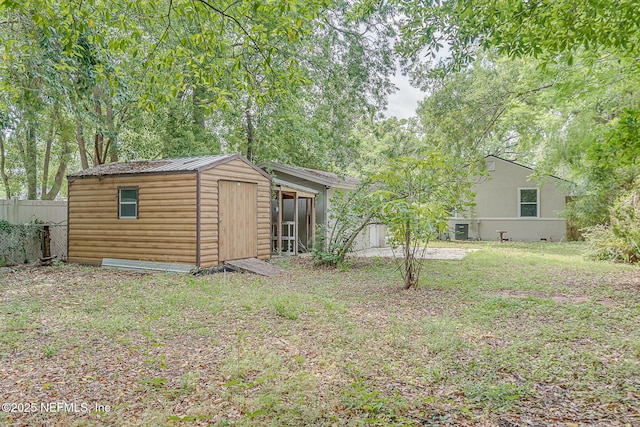 4059 College St, Jacksonville, FL 32205 - exterior space with metal roof, a storage shed, a lawn, an outbuilding, and fence