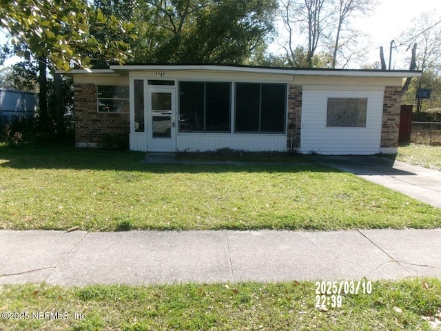 view of front facade featuring brick siding and a front yard