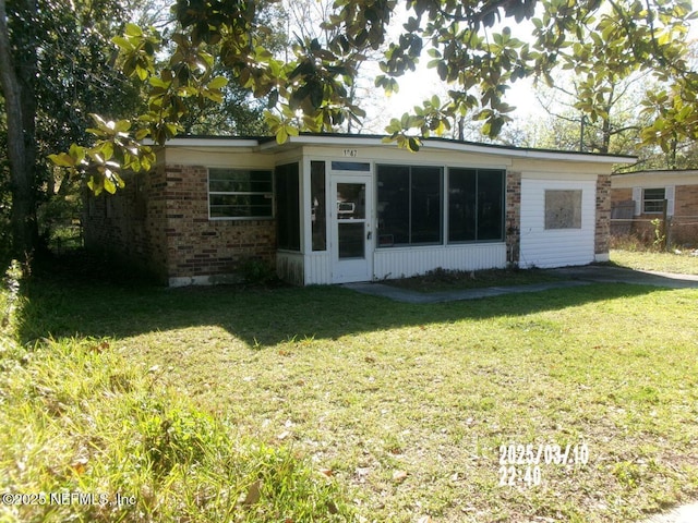 view of front of property featuring brick siding and a front lawn