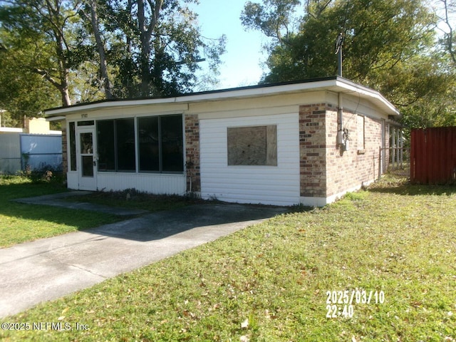 view of front of house featuring a front yard, fence, and brick siding