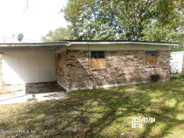 view of property exterior featuring brick siding and a lawn