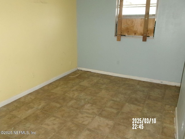 empty room with tile patterned floors and baseboards