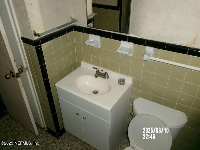 bathroom featuring vanity, tile walls, toilet, and tile patterned flooring