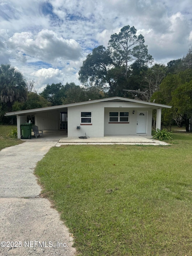 view of front of property featuring an attached carport, driveway, and a front yard