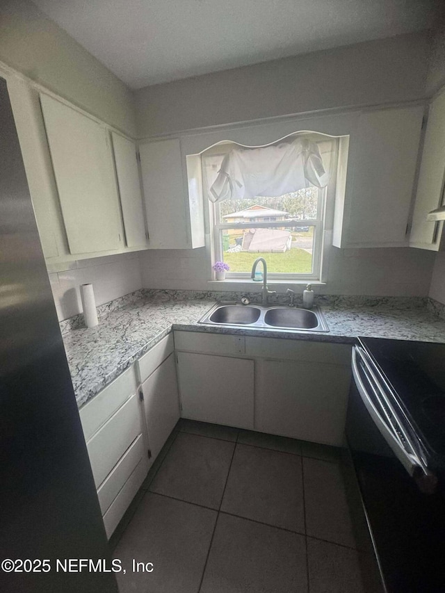 kitchen with light countertops, white cabinets, black electric range oven, and a sink