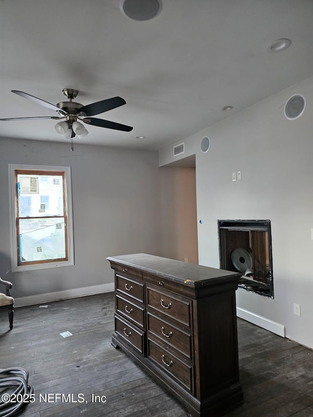 interior space with visible vents, baseboards, ceiling fan, and dark wood-style flooring