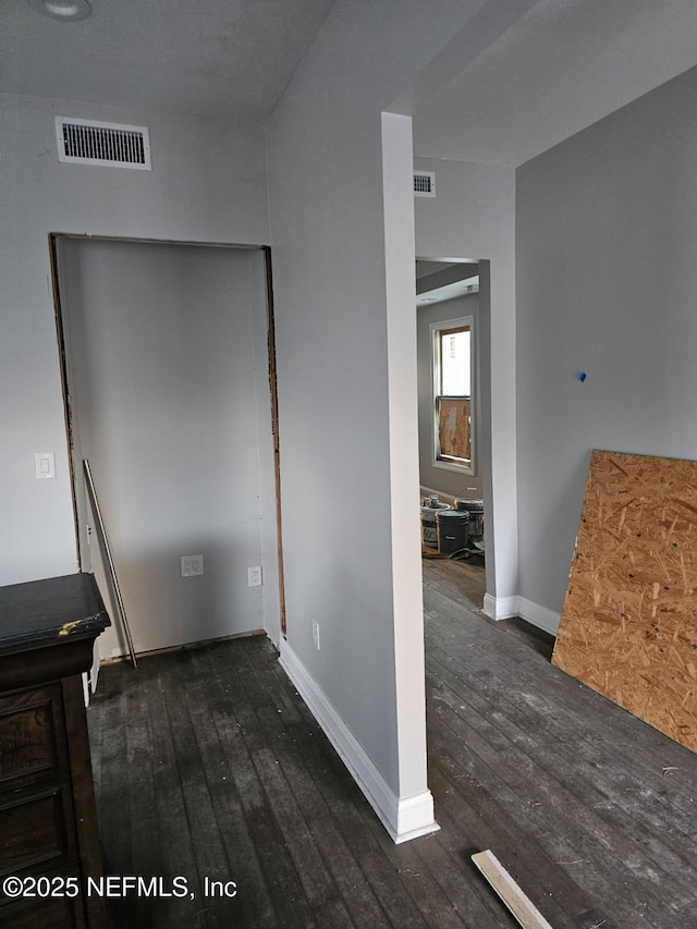 unfurnished bedroom with visible vents, baseboards, and dark wood-style floors